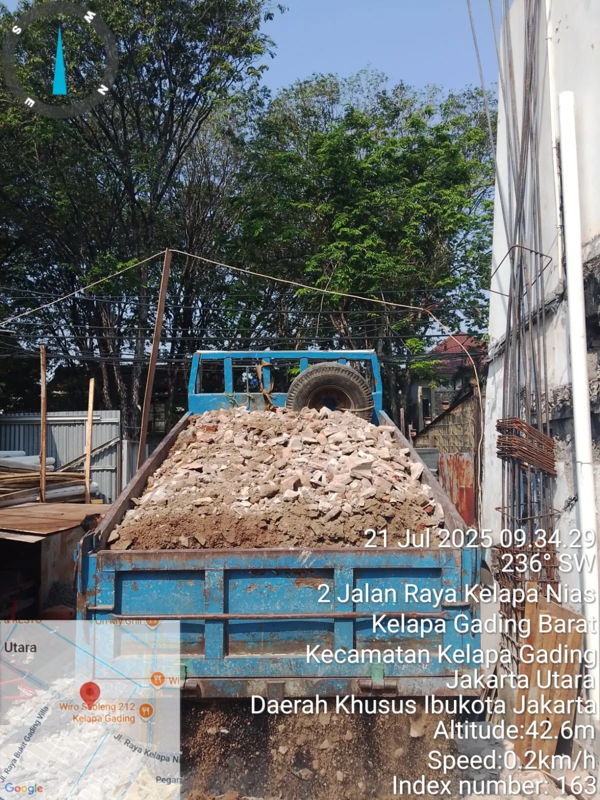 Truk biru bermuatan penuh material bongkaran