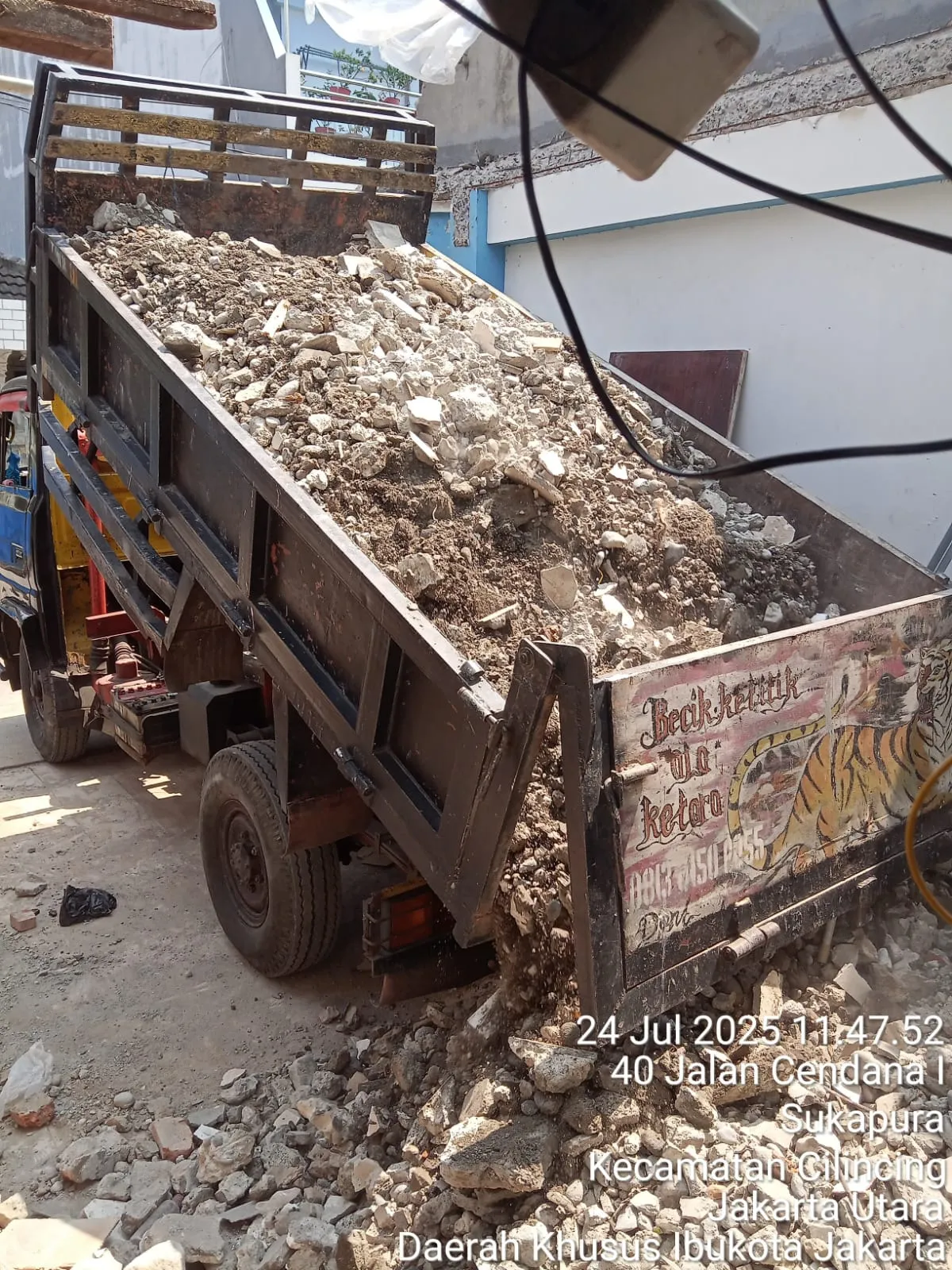 Proses menumpahkan muatan puing dari bak truk