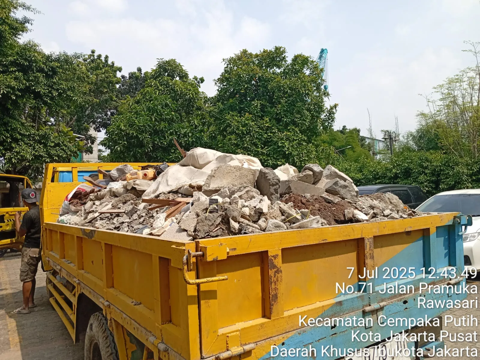 Bak truk kuning penuh puing bongkaran